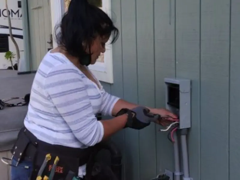 Licensed electrician wiring an exterior subpanel in Andrews AFB